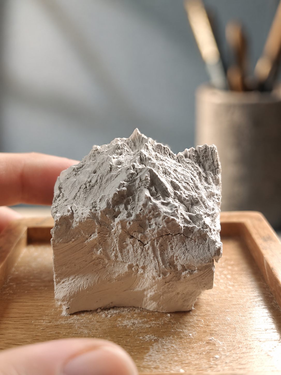 Hand carving a miniature mountain form